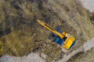 Stunning aerial view of the stopped yellow excavator at a constr